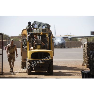 Un chariot de levage Hyster du détachement de transit interarmées (DéTIA) charge des caisses de matériels depuis un camion GBC-180 en zone logistique de Gao, au Mali.