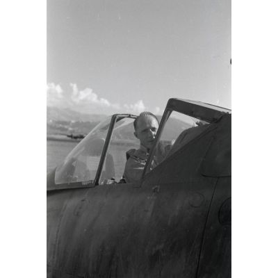 Avec l'aide d'un mécanicien, un pilote enfile un parachute avant de monter à bord d'un chasseur Fw-190.