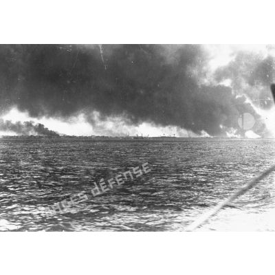 Plan général du port de Dunkerque en feu photographié de la mer.