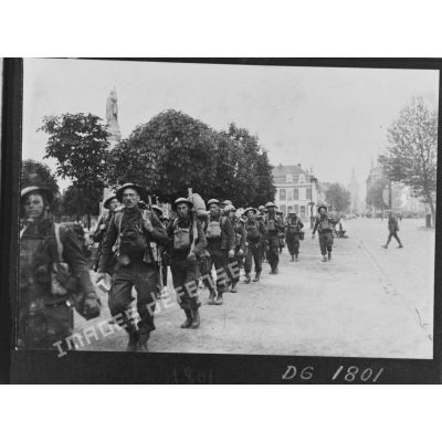 Une colonne de soldats de la BEF marche dans une rue de Béthune.