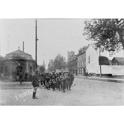 Une colonne de soldats de la BEF marche dans la rue Sadi Carnot de Béthune.