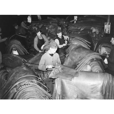 Des ouvriers s'activent dans l'entrepôt de feuilles de cuir de l'usine de chaussures.
