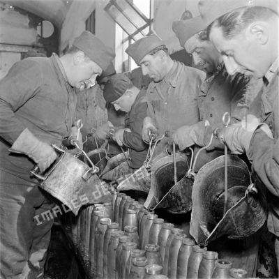 Des ouvriers versent de la mélinite dans des obus.
