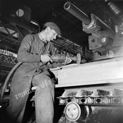 A l'atelier d'Issy-les-Moulineaux un ouvrier ponce la caisse d'un char Renault R40.
