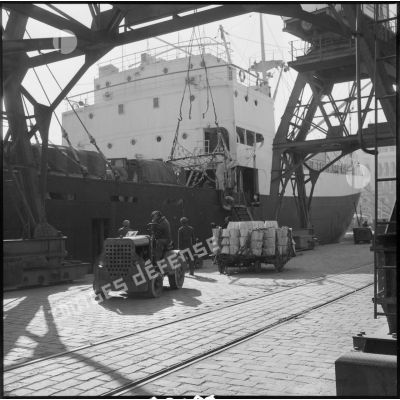 Embarquement de marchandises dans le port d'Alger.