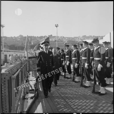 Accompagné du commandant du Georges Leygues, monsieur Robert Lacoste passe en revue la garde d'honneur.