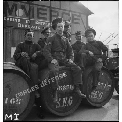 Soldats de la British expeditionary force (BEF) assis sur des fûts de bière dans le port de Brest.