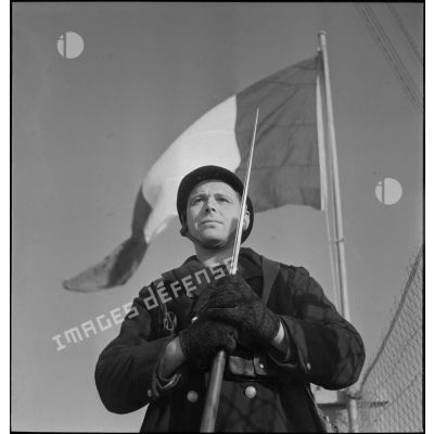 Portrait en contre-plongée d'un marin, sentinelle de la défense côtière dans la région de Brest.