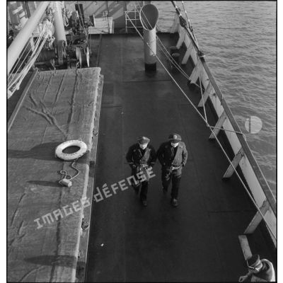 Marins français circulant sur le pont du navire marchand allemand le Rostock.