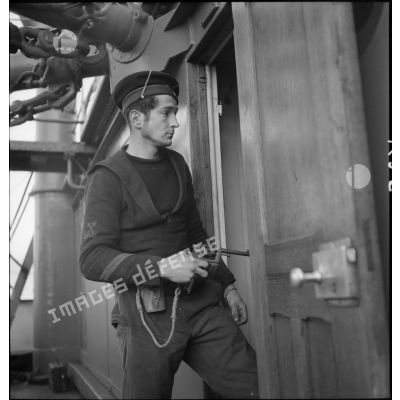 Portrait d'un quartier maître de 2e classe, membre d'équipage de l'aviso dragueur de mines Elan, pistolet au poing à bord du navire marchand allemand le Rostock.