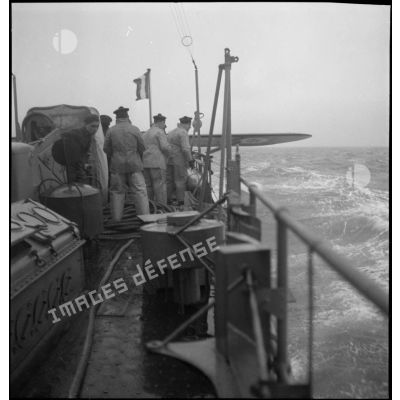 A l'issue d'un vol de reconnaissance, un hydravion Latécoère 290 est arrimé à la bigue sur le pont arrière du chasseur de sous-marins n°5 (CH 5) afin d'être remorqué.