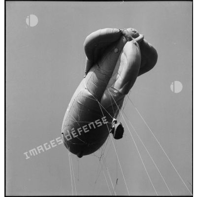 Ballon d'observation captif s'élevant dans les airs, avec ses câbles de retenue.