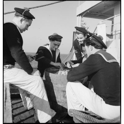 Des marins font une partie de cartes sur le pont du cargo réquisitionné Yang Tsé.