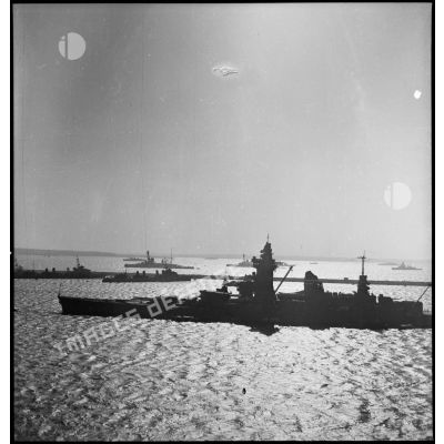 Vue bâbord du cuirassé Dunkerque au mouillage sur coffre dans une rade.