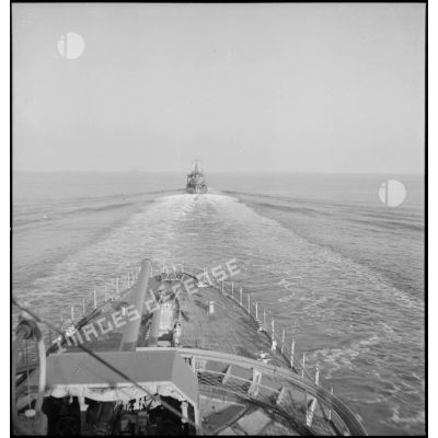 Un convoi de contre-torpilleurs d'une escadre navigue en ligne de file. Au premier plan, canons de 138 mm sur la plage avant.