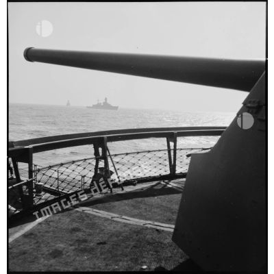 Croiseur ou cuirassé au sein d'un convoi vu depuis une des tourelles d'un contre-torpilleur.