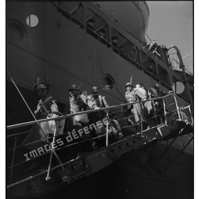 Des soldats nord-africains descendent du paquebot transport de troupes Ville d'Alger par l'échelle de coupée dans le port de Marseille.