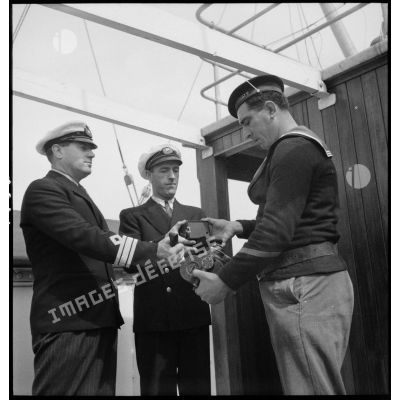 Les officiers du cargo italien Tagliamento, arraisonné par la police de la navigation, remettent leurs appareils photographiques et caméras.