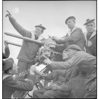 Marins et légionnaires autour d'un canon antiaérien sur un paquebot dans le port de Brest.