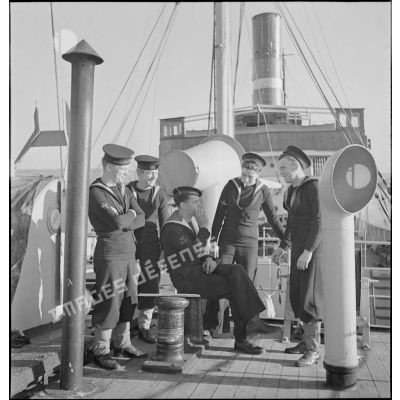 Des marins britanniques et français discutent sur le pont d'un cargo saisi par la Royal Navy et remis à la Marine nationale.
