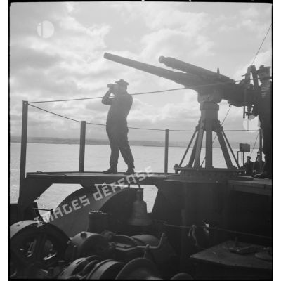 Marins à leur poste de veille au canon de 75 mm à bord d'un chalutier réquisitionné et armé par la Marine nationale.