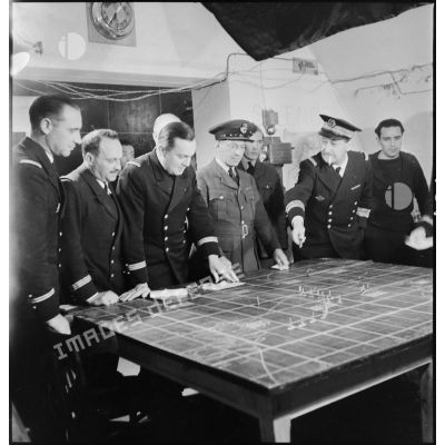 Des officiers de la Marine nationale et de la RAF (Royal Air Force) sont rassemblés devant une carte dans la salle des opérations du poste de commandement à Dunkerque.