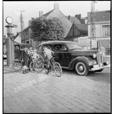 Des familles belges fuient l'invasion de leur pays par l'armée allemande à bord de véhicules et font le plein de carburant lors d'une halte à Boulogne-sur-Mer.