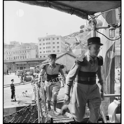 Des légionnaires du 1er régiment étranger d'infanterie (REI) montent à bord du contre-torpilleur L'Indomptable, amarré dans le port d'Oran.