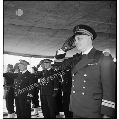 Le capitaine de frégate Edouard Deprez, commandant le contre-torpilleur Le Malin, salue pendant les honneurs rendus au vice-amiral d'escadre Marcel Gensoul en visite d'inspection.