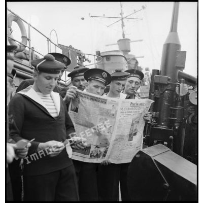 Des officiers mariniers, quartiers-maîtres et marins du contre-torpilleur Le Malin lisent la presse (quotidien Paris-Soir) et leur courrier.