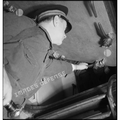 Alerte à bord du cuirassé Dunkerque : l'ingénieur en chef verrouille un panneau d'accès.
