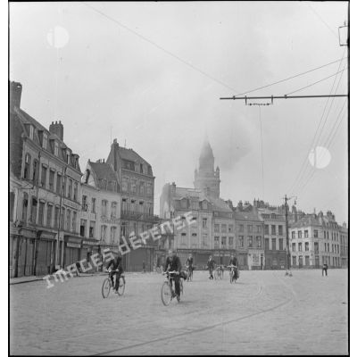 Cyclistes circulant dans Dunkerque après un bombardement de l'aviation allemande.