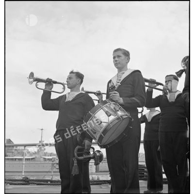Tambours et clairons à bord du cuirassé Dunkerque pendant la célébration d'un office sur le navire.