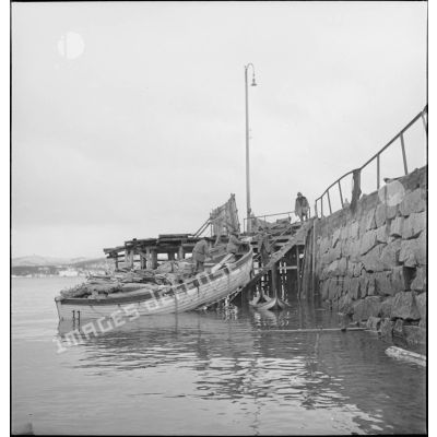 Récupération de matériels divers par des marins français dans le port de Namsos en ruine.