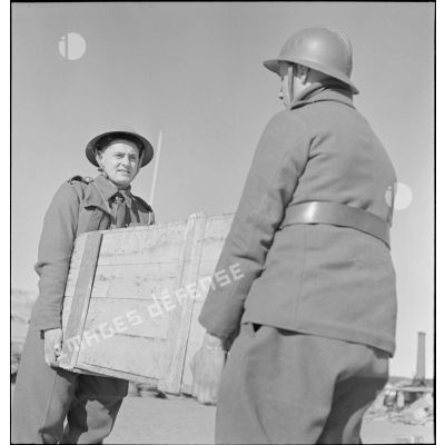 Transport d'une caisse de matériel ou de vivres par deux soldats alliés à Namsos.