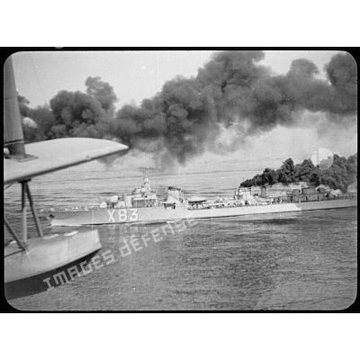 Vue aérienne depuis un hydravion du contre-torpilleur Le Triomphant (numéro de coque X 83), dont une des cheminées émet une fumée épaisse.