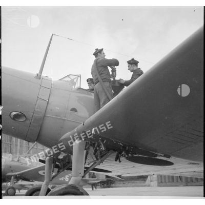 Deux matelots effectuent le plein de carburant d'un bombardier Vought 156 F de l'escadrille AB1 à Cherbourg.
