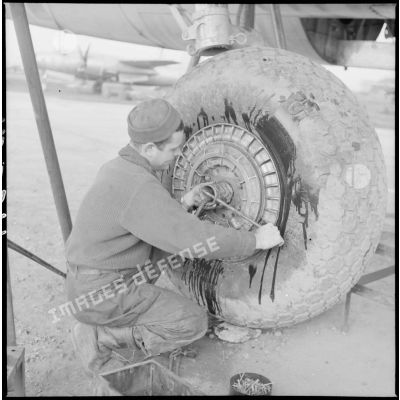 Avant la mission, un mécanicien s'affaire autour d'une roue d'avion Marauder.