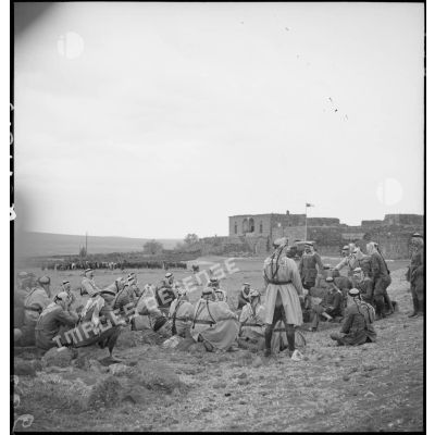Près d'un village, des cavaliers druzes se tiennent en demi-cercle autour de leurs cadres.