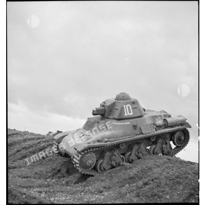 Le char léger Hotchkiss M39 H de la 3e DLM baptisé l'invulnérable franchit un remblai de terre.