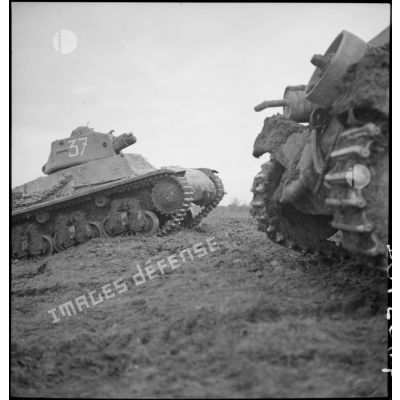 Des chars légers Hotchkiss M39 H de la 3e DLM franchissent un remblai de terre.