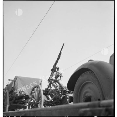 Une mitrailleuse Hotchkiss modèle 1914 sur affût hippotracté est photographiée sur un wagon ouvert.