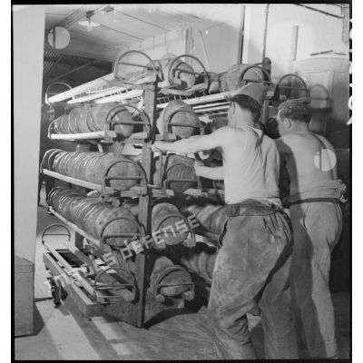 Des soldats rangent des pains cuits sur des étagères.