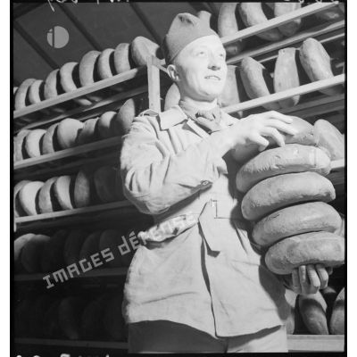 Plan américain d'un soldat qui porte des pains.