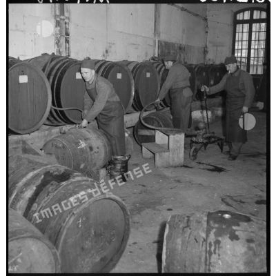 Plan général de soldats qui vident des tonneaux de vin dans un entrepôt.
