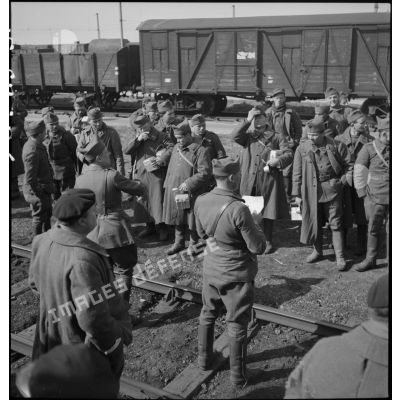 Photographie de groupe de soldats près d'une voie ferrée en gare de Trappes.