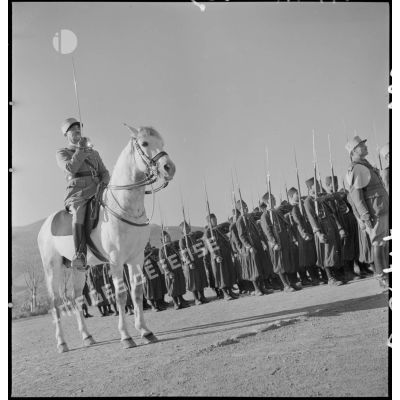 Une compagnie du 1er RTA présente les armes, au premier plan un capitaine à cheval  présente le sabre.