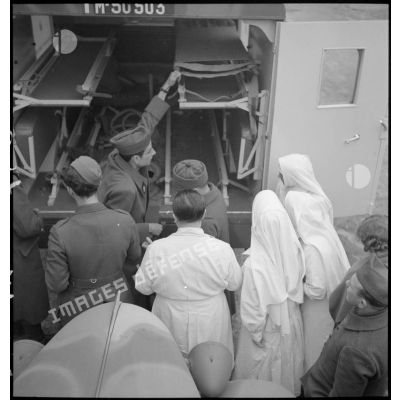 Des soldats français embarquent un blessé de circonstance à bord d'une ambulance de la section sanitaire de volontaires américains (SSVA).