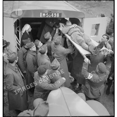 Des soldats français embarquent un blessé de circonstance à bord d'une ambulance (immatriculée M-50498) de la section sanitaire de volontaires américains (SSVA).