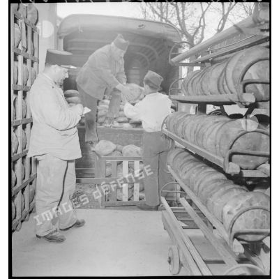 Des soldats chargent les pains dans un camion.